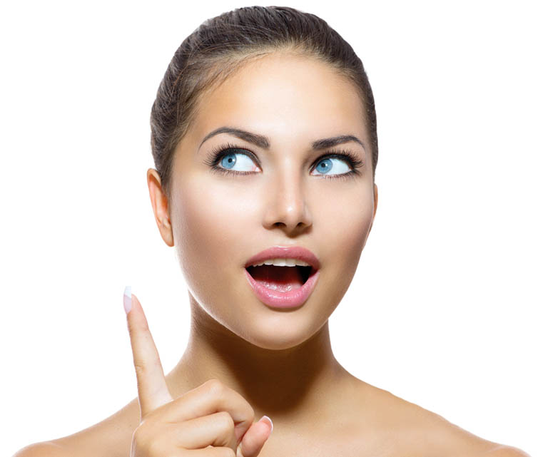 Junge Frau zeigt begeistert nach oben mit überraschter Mimik.